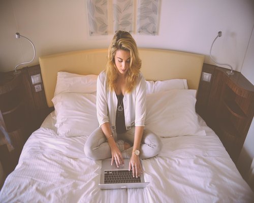 Person resting eyes while working on a laptop in a relaxed home environment